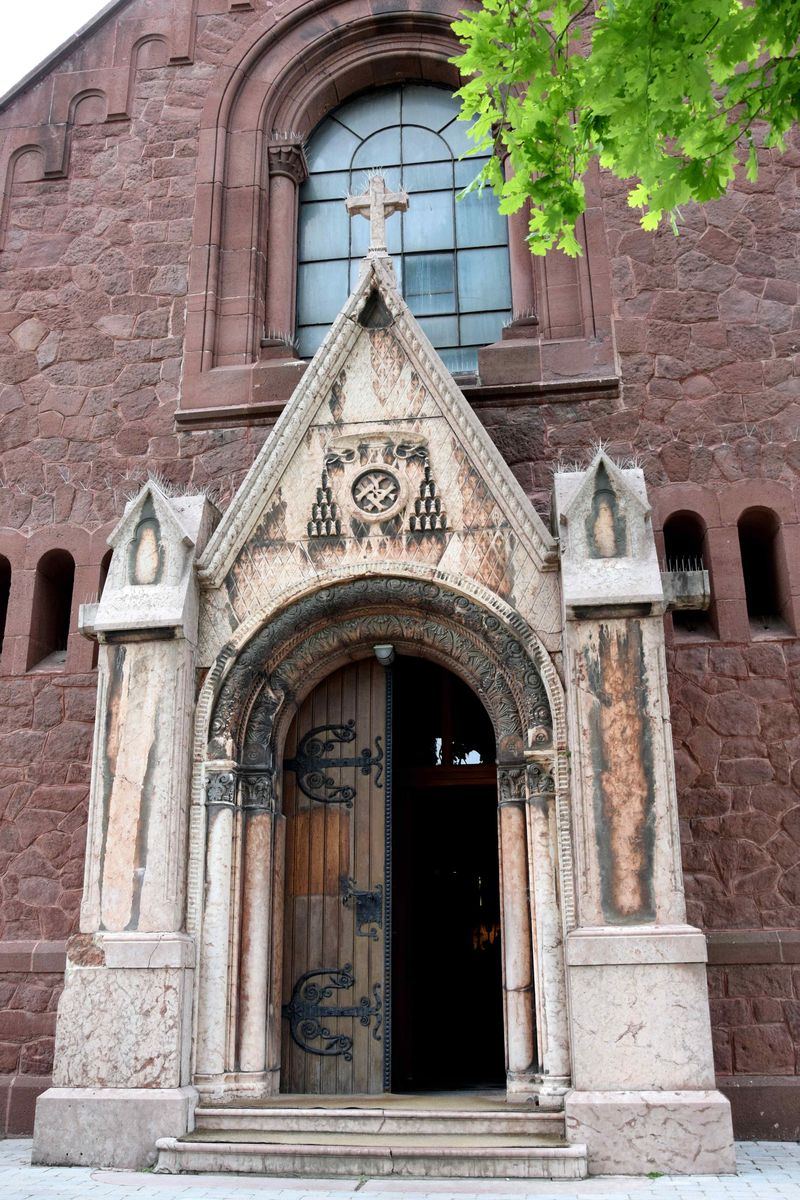A Károly-templom főhomlokzata, a kapu oromzatában Honig Károly monogramja a bíborosi rangot jelző kalappal (Fotó: VFKL 2021)